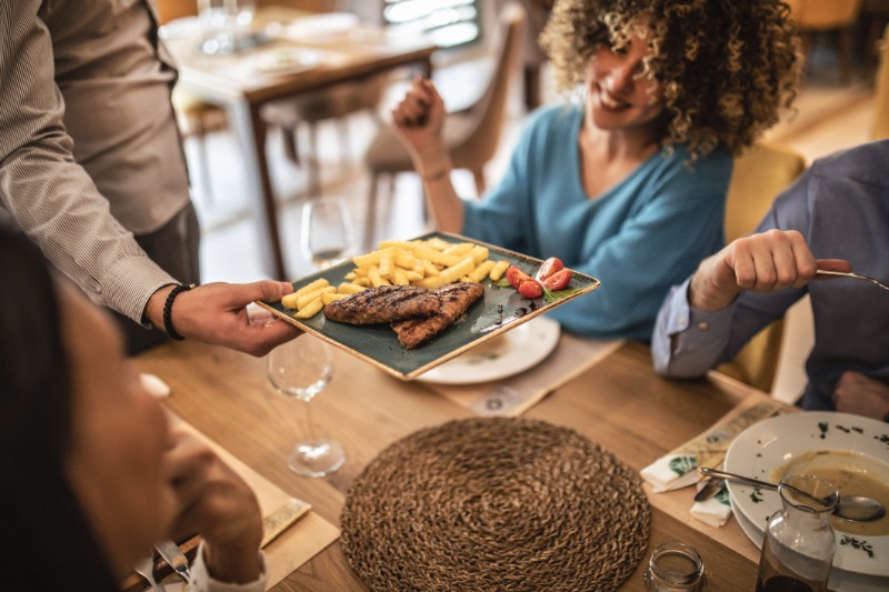 Group of happy friends having a lunch in restaurant